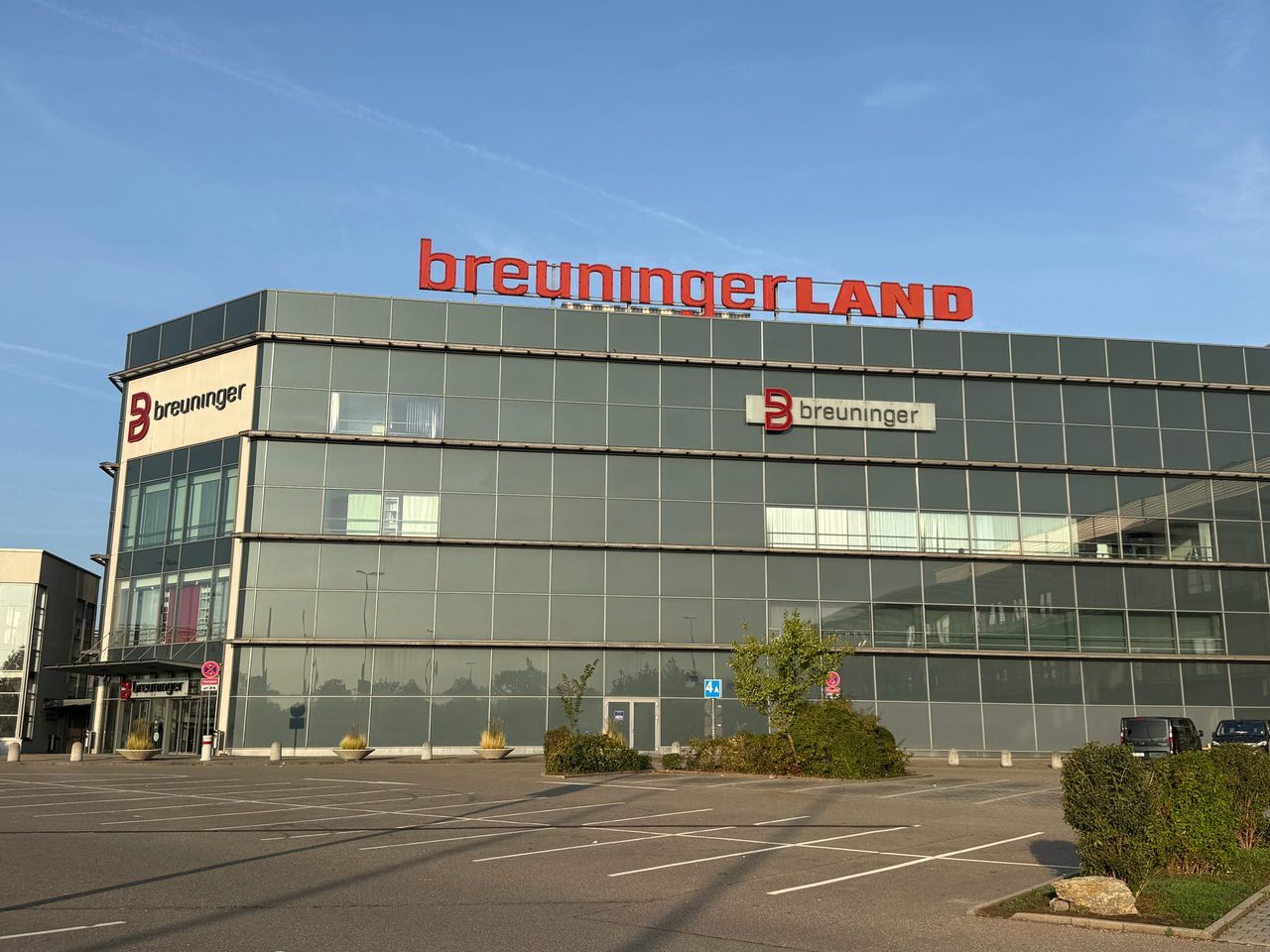 Glasfassade des Breuningerland Ludwigsburg mit rotem Schriftzug über dem Parkplatz