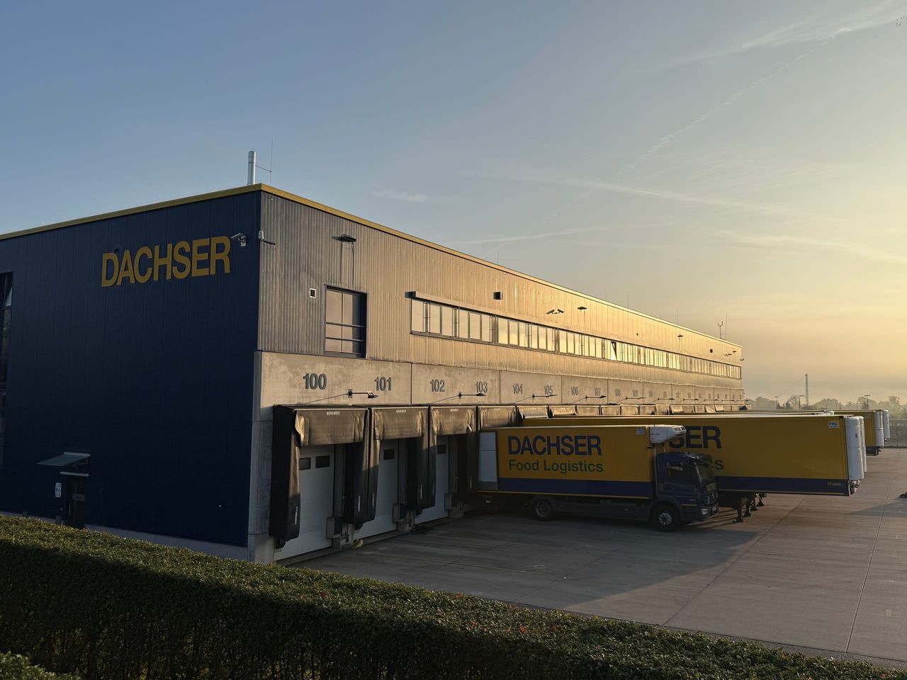 Logistikhalle von DACHSER in Kornwestheim mit Laderampe und LKW im Morgenlicht