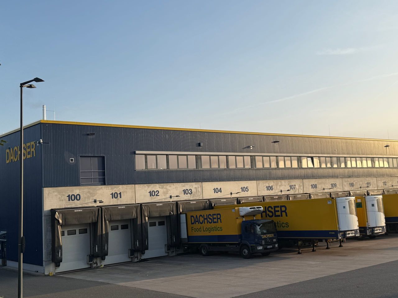 Seitliche Ansicht der Laderampe mit nummerierten Verladetoren und abgestellten LKW
