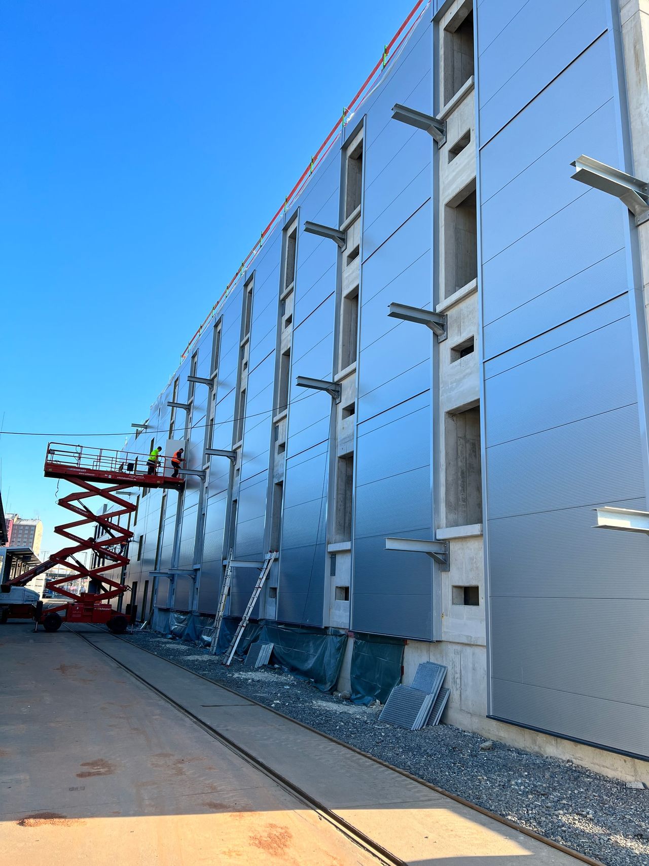 Hochformat der grauen Metallfassade des Chemielagers mit Türöffnungen in mehreren Ebenen