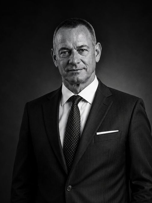 Bernd Ocker, Geschäftsführer der Ocker Werkzeughandel GmbH, im Anzug vor dunklem Hintergrund