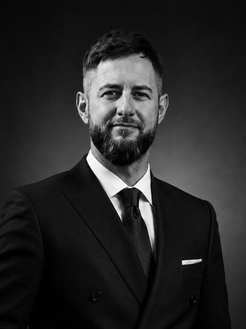 Chris Ocker, Geschäftsführer der Ocker Werkzeughandel GmbH, im Anzug vor dunklem Hintergrund
