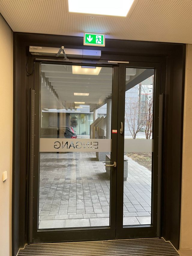 Gläserne zweiflügelige Eingangstür mit Feststellanlage